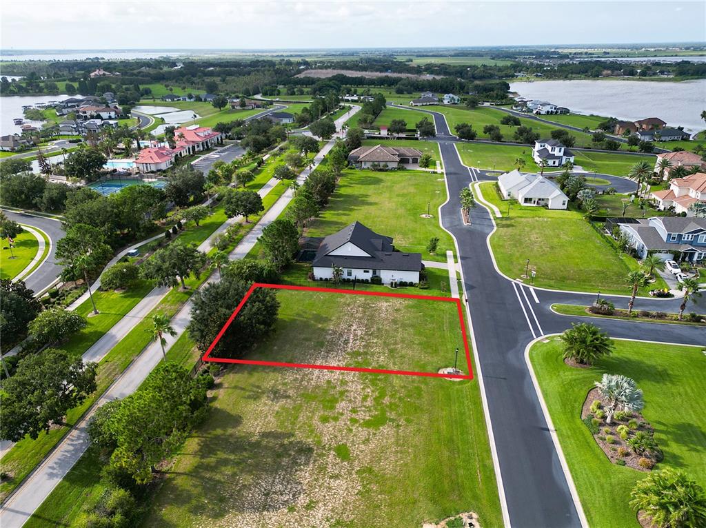 An aerial view shows a vacant residential lot outlined in red next to a house — 231 BLAZING STAR AVENUE, LAKE ALFRED, FL