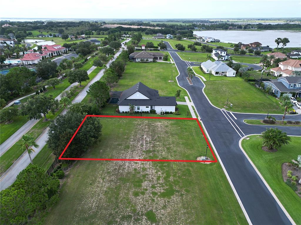 An aerial view shows a vacant residential lot outlined in red next to a paved road — 231 BLAZING STAR AVENUE, LAKE ALFRED, FL