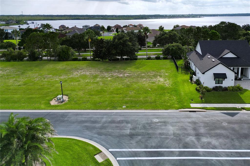 An aerial view shows a vacant residential lot next to a house near a lake — 231 BLAZING STAR AVENUE, LAKE ALFRED, FL