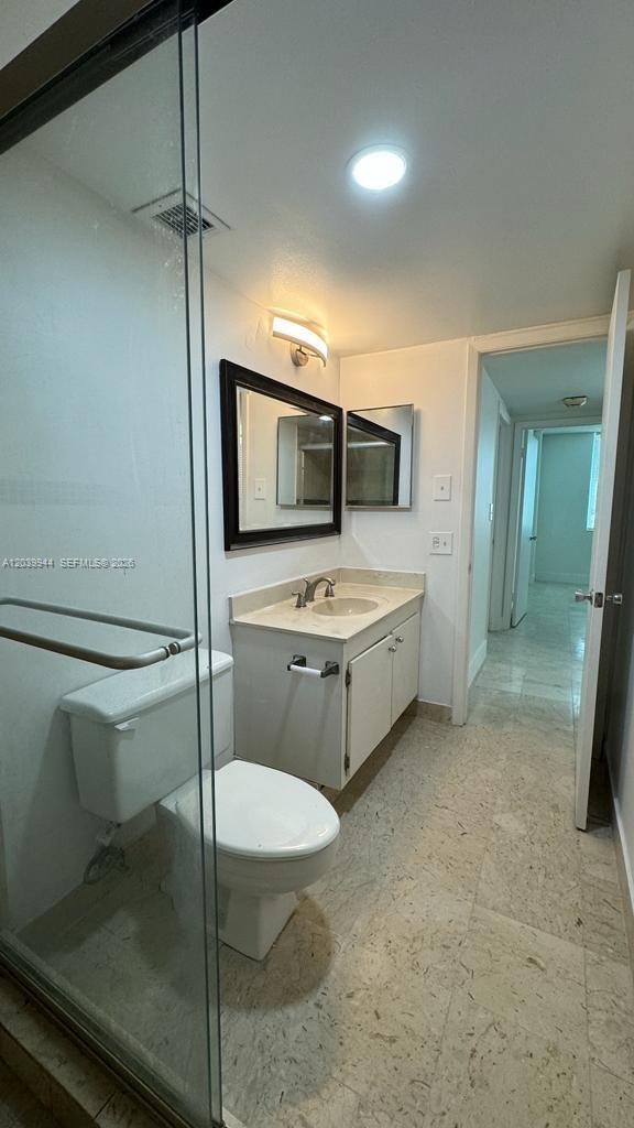 A bathroom features a glass-enclosed shower, a white vanity with a sink, and tile flooring — 919 Hillcrest Dr # 201, Hollywood FL 33021, HOLLYWOOD, FL