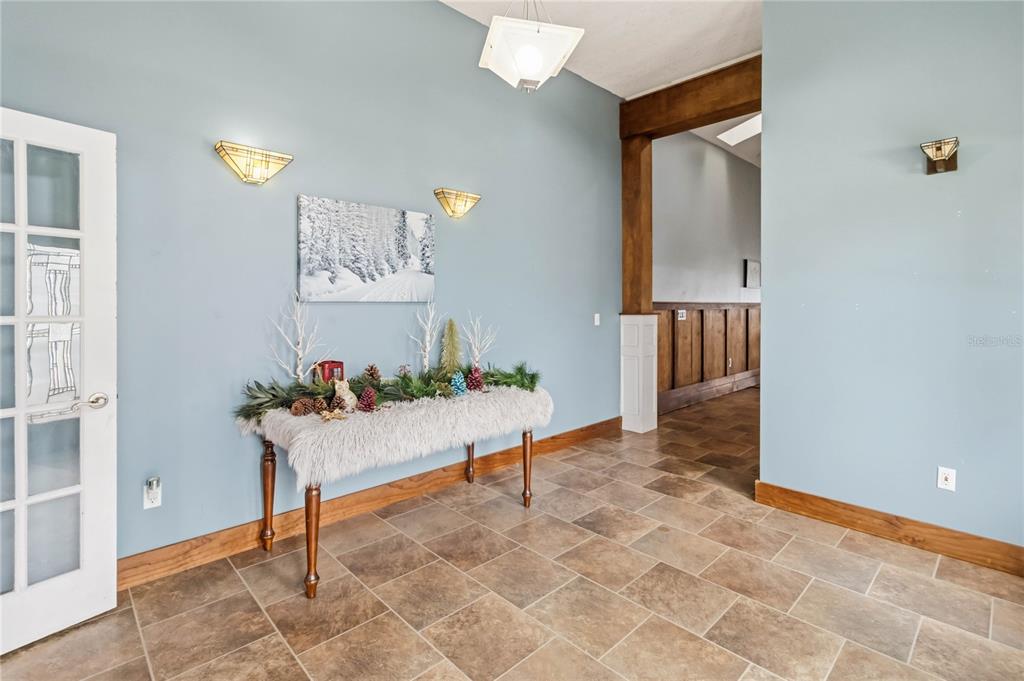An entryway features blue walls, tile flooring, a fur-covered console table, and decorative wall sconces — 6210 ALLIGATOR LAKE SHORE E, ST CLOUD, FL