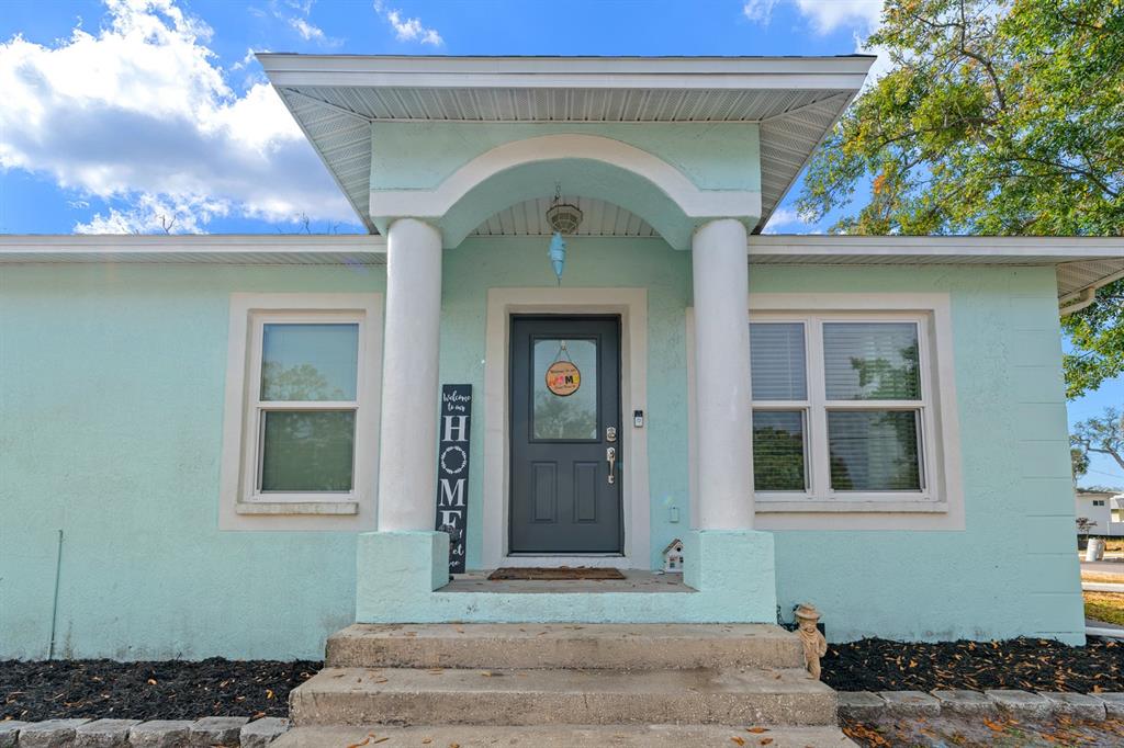 The exterior of a light blue house features a covered porch with two white columns — 5316 W IDAHO STREET, TAMPA, FL