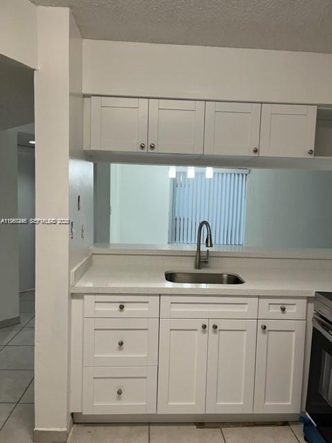 A kitchen features white cabinets, a stainless steel sink, and a pass-through window — 14020 SW 90th Ter # 14020, Miami FL 33186, MIAMI, FL