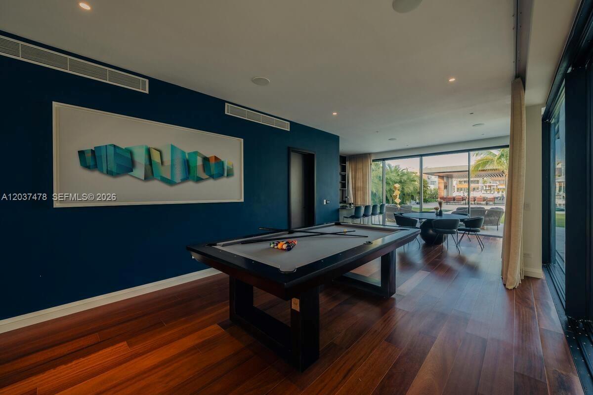 A game room features a pool table, dark blue walls, and floor-to-ceiling glass sliding doors — 0 Marina, FL