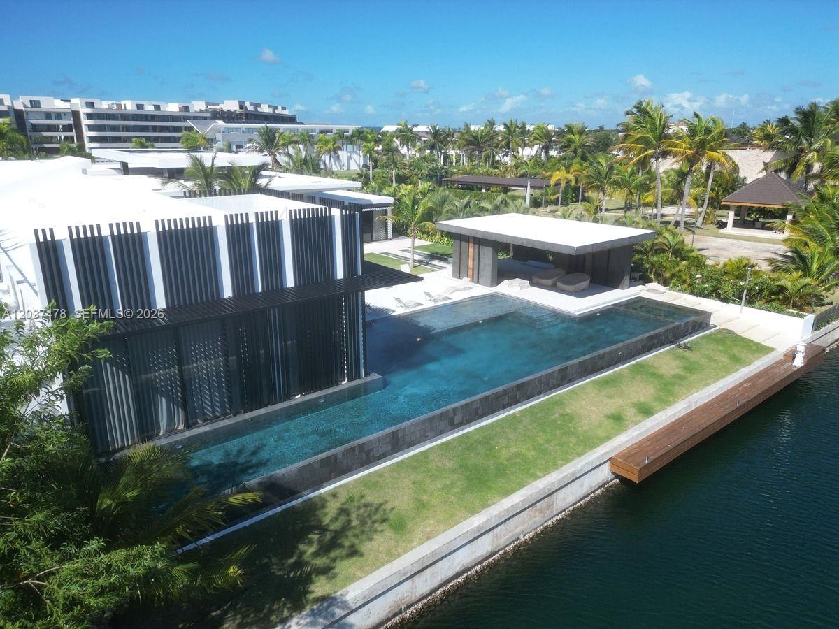An aerial view shows a modern house with a long infinity pool and wooden dock — 0 Marina, FL
