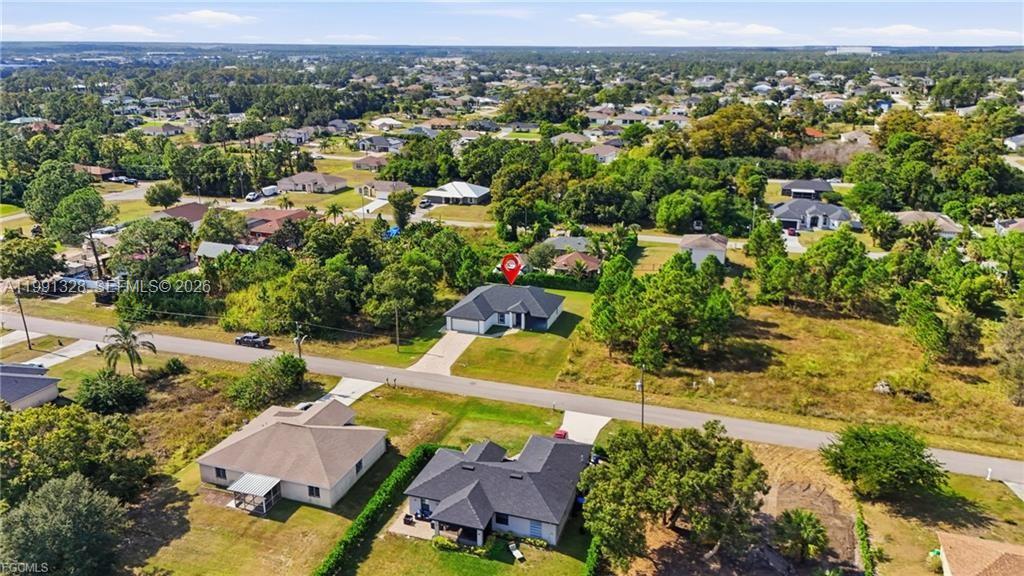 An aerial view shows a single-story house with a red location pin on a lot — 1013 ATHERTON AVE, Lehigh Acres FL 33971, LEHIGH ACRES, FL