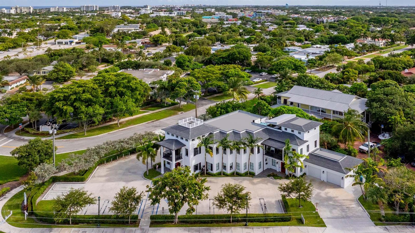 An aerial view of a white multi-story building with a flat roof and parking lot — 230 George Bush Boulevard, Delray Beach FL 33444, DELRAY BEACH, FL