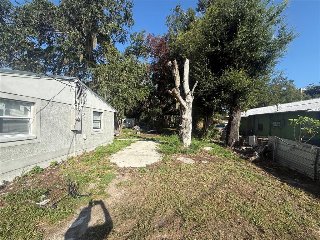 An unfinished room features a kitchen counter, exposed ceiling, and bare concrete floors — 608 S ORANGE AVENUE, ARCADIA, FL