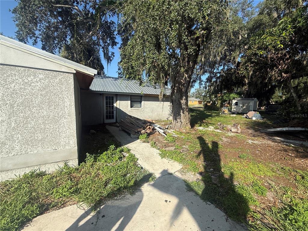 An empty room with a chandelier, a window with blinds, and unfinished concrete flooring — 608 S ORANGE AVENUE, ARCADIA, FL