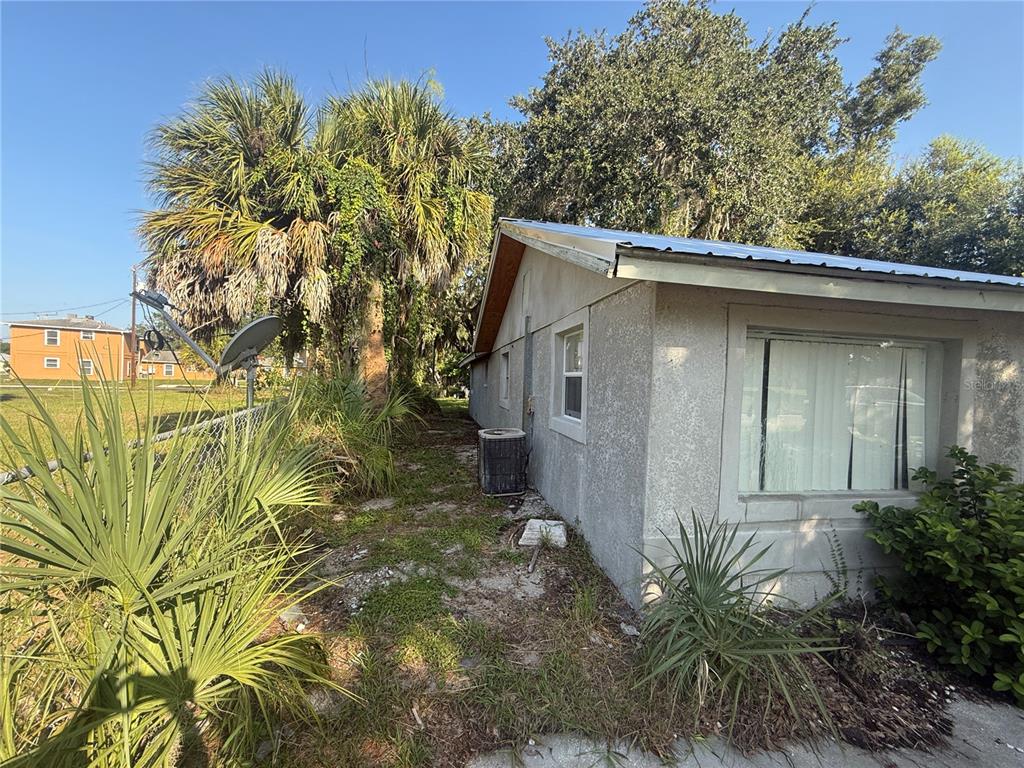 An unfinished room features gray walls, a ladder, a kitchen cabinet base, and paint cans — 608 S ORANGE AVENUE, ARCADIA, FL
