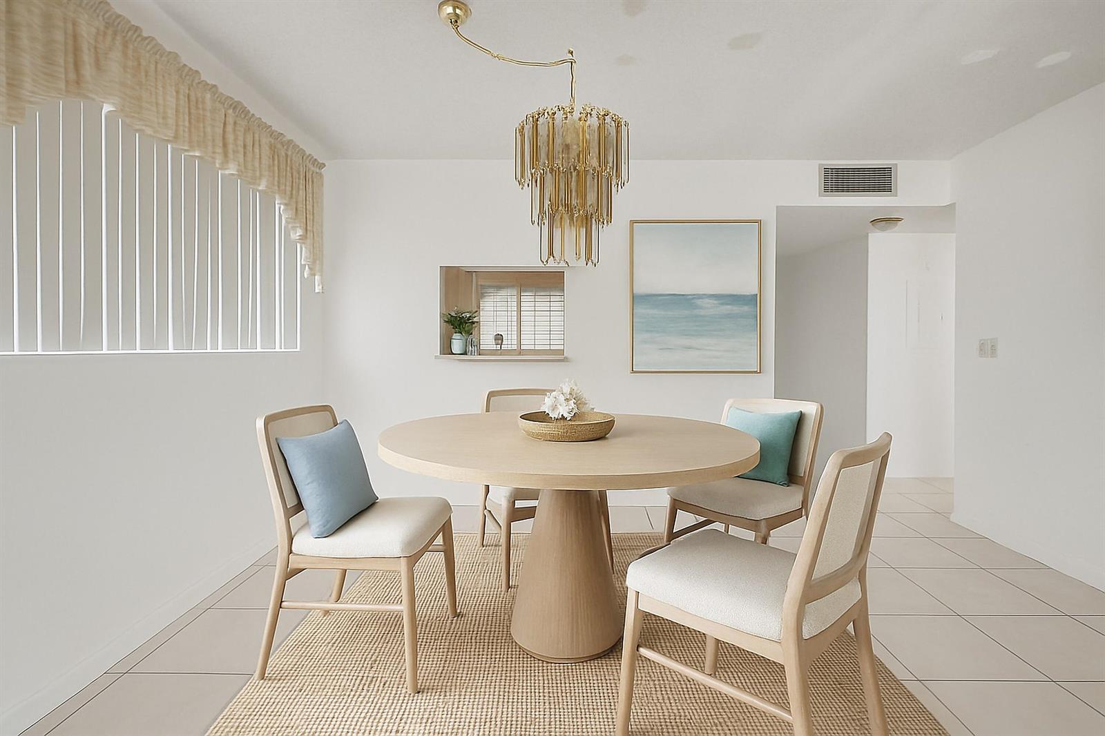 A dining room features a round wooden table, four chairs, and a gold tiered chandelier — 6670 Royal Palm Boulevard # 314k, Margate FL 33063, MARGATE, FL