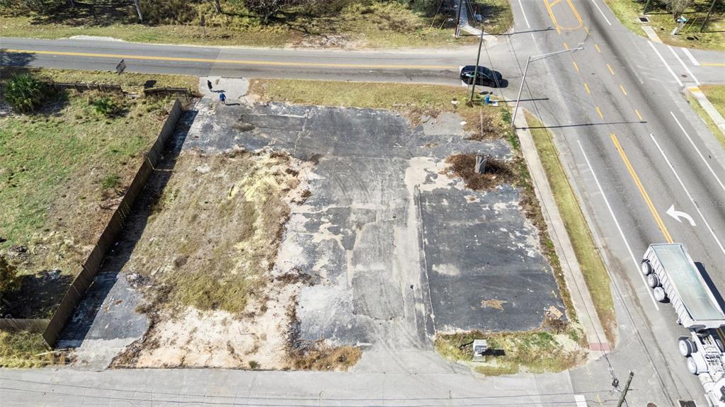 An aerial view shows a vacant, paved lot situated at a road intersection — 331 W MYERS BOULEVARD, MASCOTTE, FL
