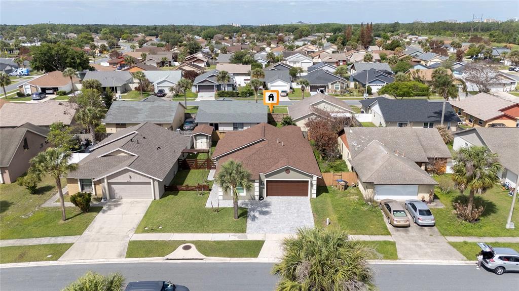 An aerial view shows a suburban house with a brown roof and a paved driveway — 4980 WARRIOR LANE, KISSIMMEE, FL