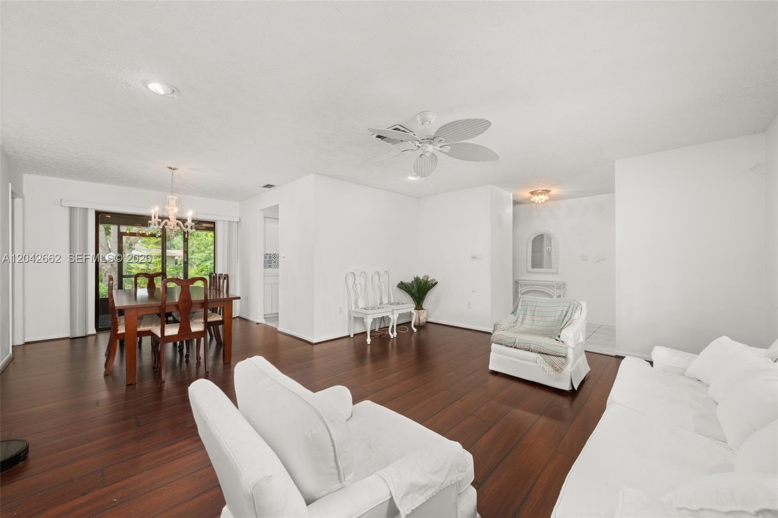 A living and dining room features white walls, dark wood flooring, and a ceiling fan — 4524 Harder Avenue, Sebring FL 33875, SEBRING, FL