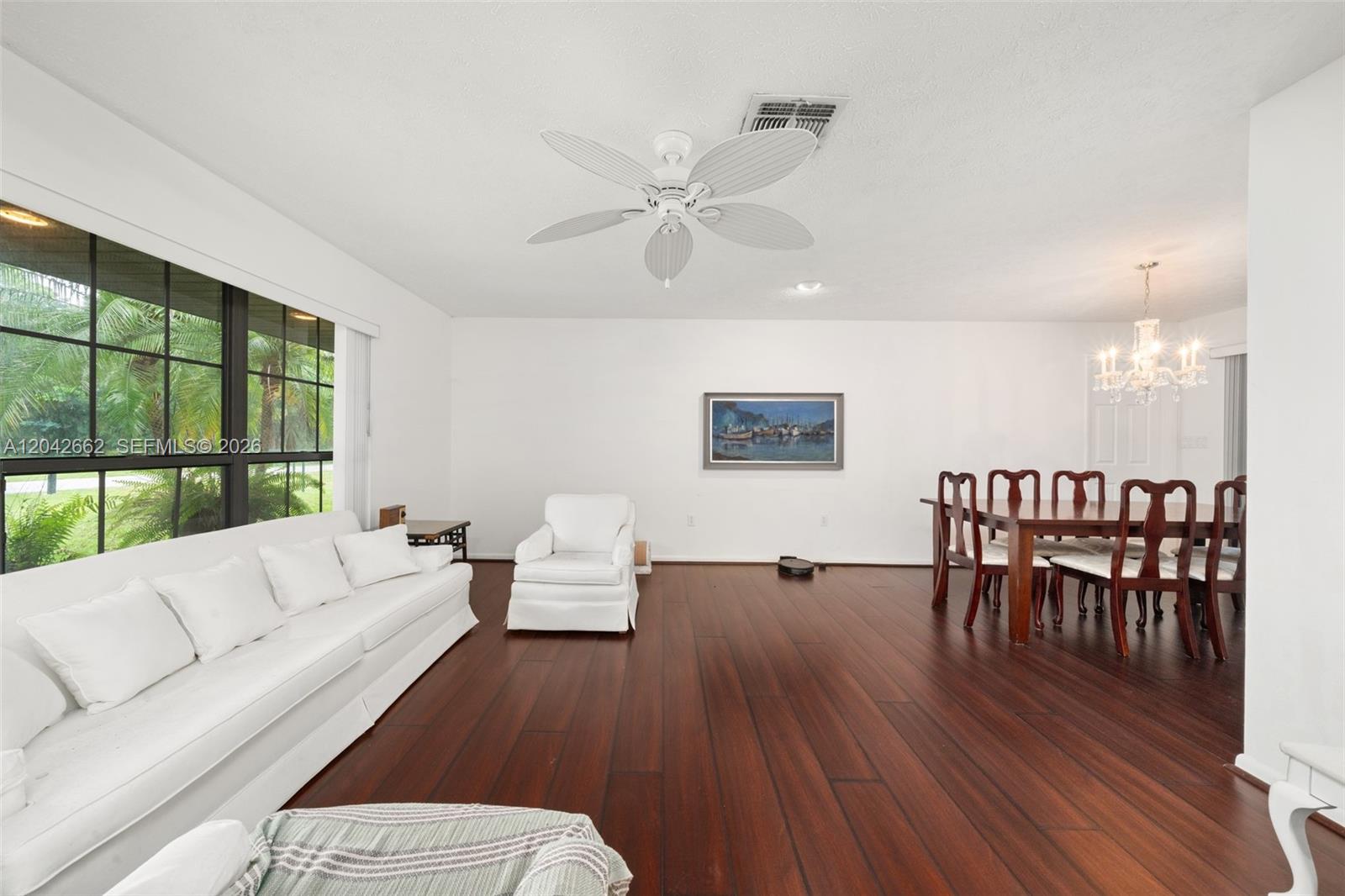 A living and dining area features dark wood floors, white furniture, and a ceiling fan — 4524 Harder Avenue, Sebring FL 33875, SEBRING, FL