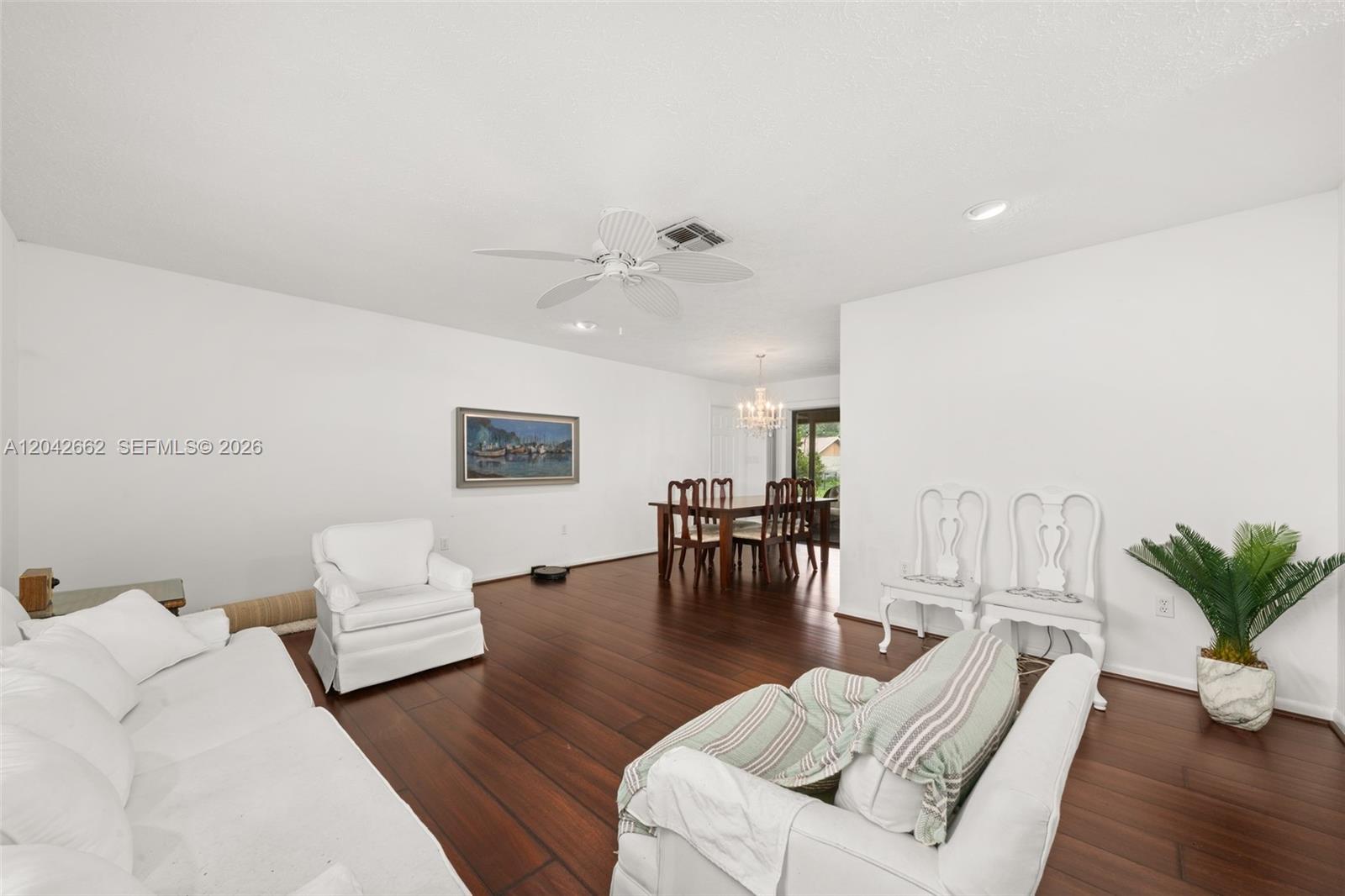 A living and dining area features white walls, dark wood flooring, and white furniture — 4524 Harder Avenue, Sebring FL 33875, SEBRING, FL