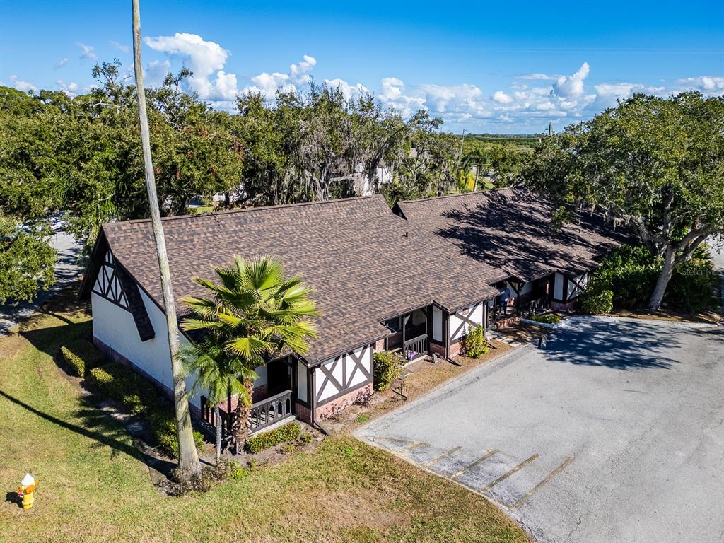An aerial view shows a single-story building with Tudor-style architecture and a brown shingled roof — 310 N BAYSHORE BOULEVARD UNIT 103, CLEARWATER, FL