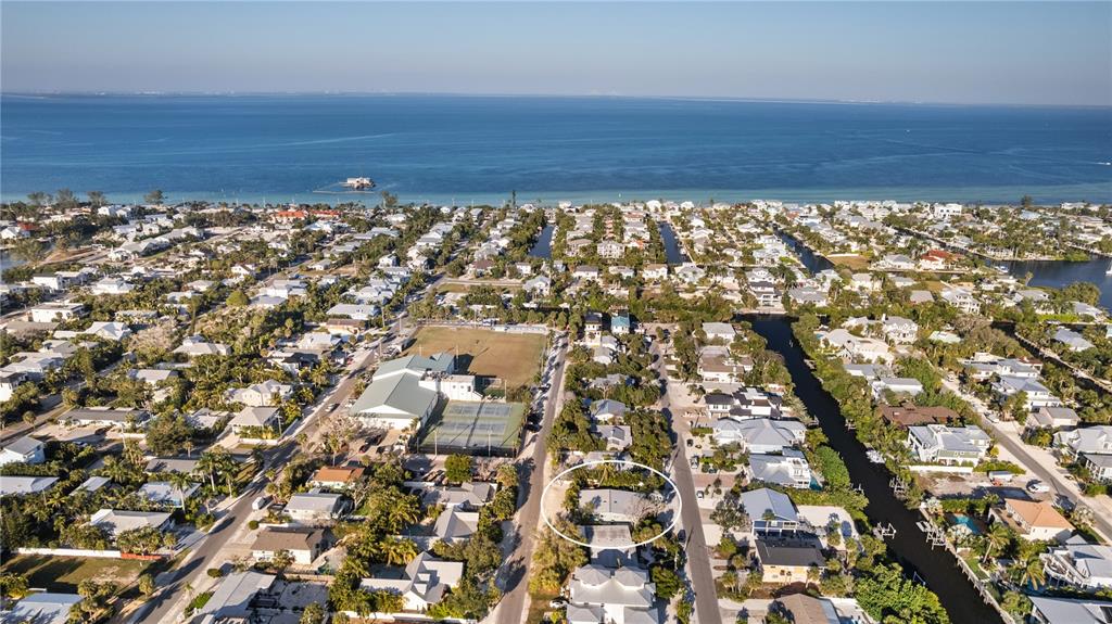 An aerial view shows a residential neighborhood with a circled house near a canal — 312 HARDIN AVENUE, ANNA MARIA, FL