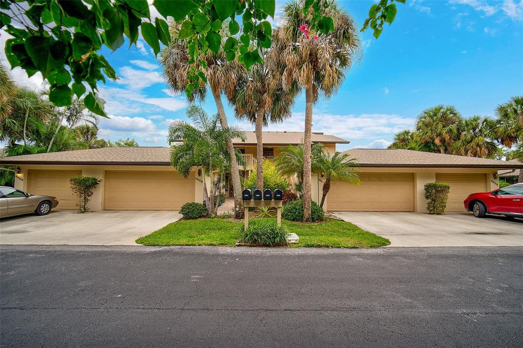 A low-rise residential building features two double garages, palm trees, and a central mailbox stand — 6660 SCHOONER BAY CIRCLE UNIT 6660, SARASOTA, FL