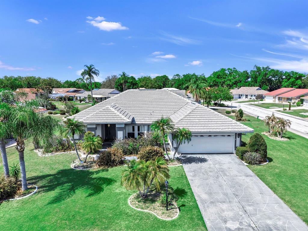 A single-story house with a tiled roof, a two-car garage, and a concrete driveway — 2003 NEW BEDFORD DRIVE, SUN CITY CENTER, FL