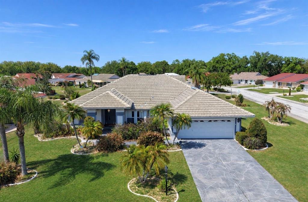 An aerial view of a single-story house with a tiled roof and a concrete driveway — 2003 NEW BEDFORD DRIVE, SUN CITY CENTER, FL