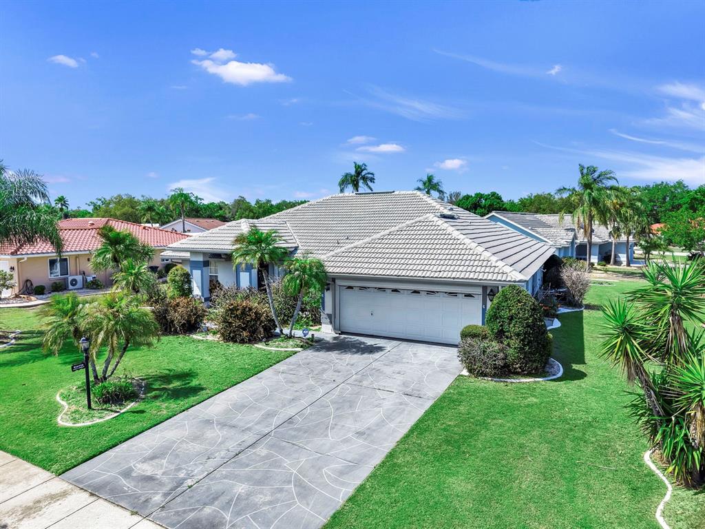 A single-story house with a tiled roof, a concrete driveway, and a green lawn — 2003 NEW BEDFORD DRIVE, SUN CITY CENTER, FL
