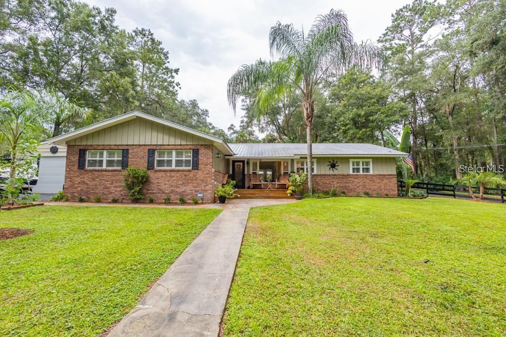A single-story brick house with a metal roof and a front walkway sits on a lawn — 3341 SE 45TH STREET, OCALA, FL