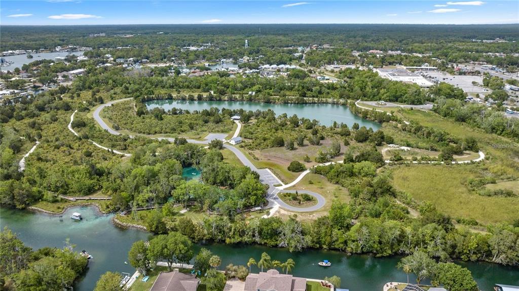 A wooden dock extends into a canal with a covered boat slip on the opposite bank — 1218 SE 4TH AVENUE, CRYSTAL RIVER, FL