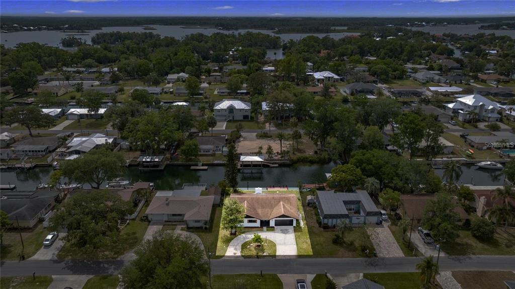 An aerial view shows a park with a spring-fed pond, walking paths, and surrounding greenery — 1218 SE 4TH AVENUE, CRYSTAL RIVER, FL