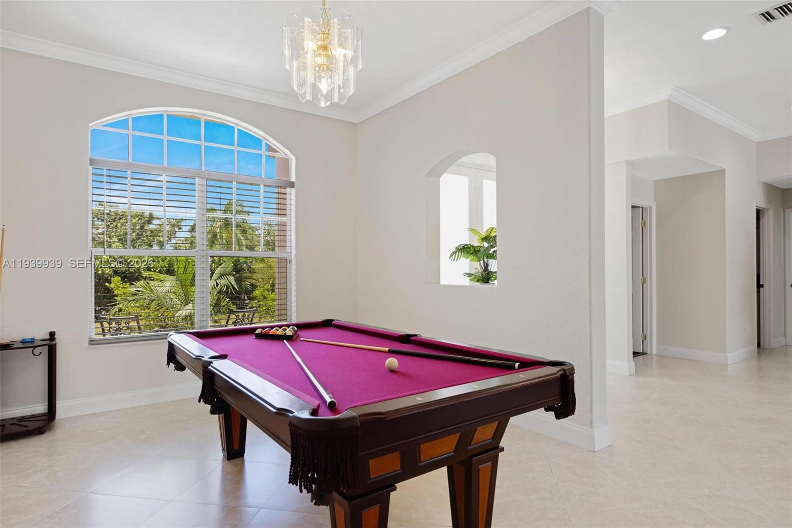 A living room features a crystal chandelier, a television on a console, and white chairs — 12851 Luray Rd, Southwest Ranches FL 33330, SOUTHWEST RANCHES, FL