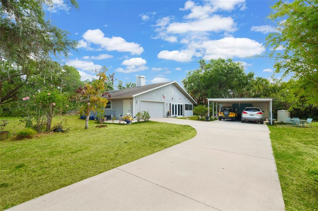 A single-story house with a gray exterior, a concrete driveway, and a detached carport — 2070 59TH STREET, SARASOTA, FL