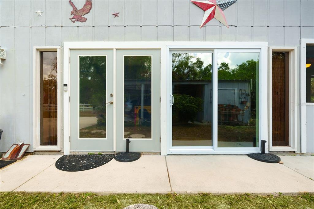 A view of a house exterior featuring double doors and a sliding glass door — 2070 59TH STREET, SARASOTA, FL