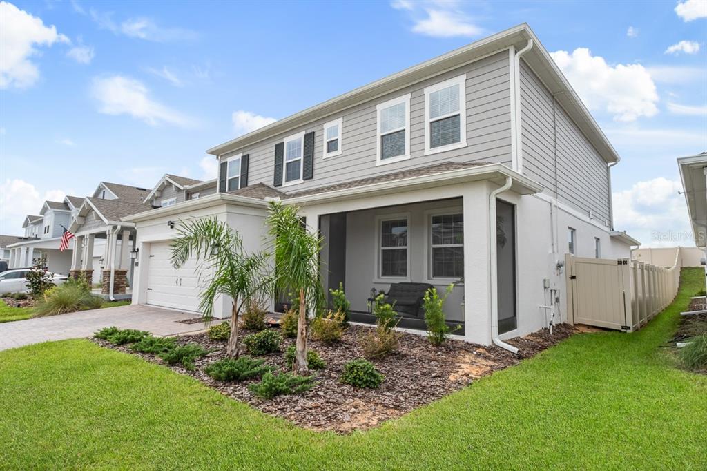 A two-story house with gray siding, a white stucco lower level, and a screened-in porch — 3204 ARMSTRONG AVENUE, CLERMONT, FL