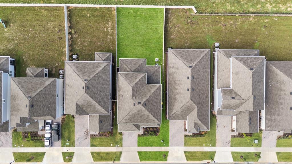 An aerial view shows a row of suburban houses with driveways and backyards — 3204 ARMSTRONG AVENUE, CLERMONT, FL