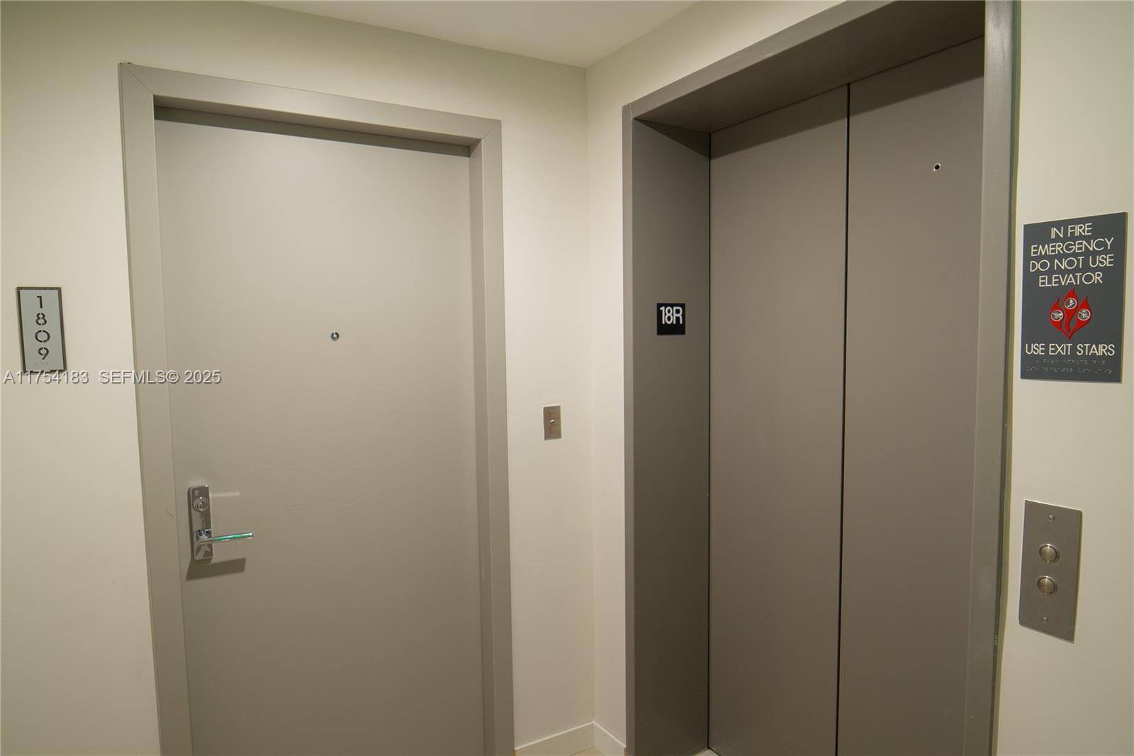 A gray door labeled 1809 sits next to a gray elevator with a fire safety sign — 488 NE 18 St # 1809, Miami FL 33132, MIAMI, FL