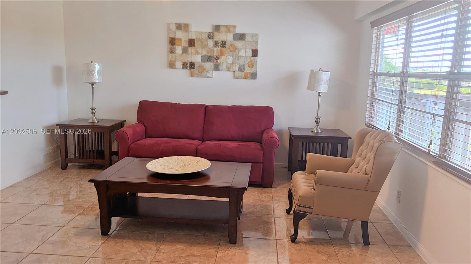 A living room features a red sofa, a beige armchair, and a dark wood coffee table — 250 Suffolk F # 250, Boca Raton FL 33434, BOCA RATON, FL