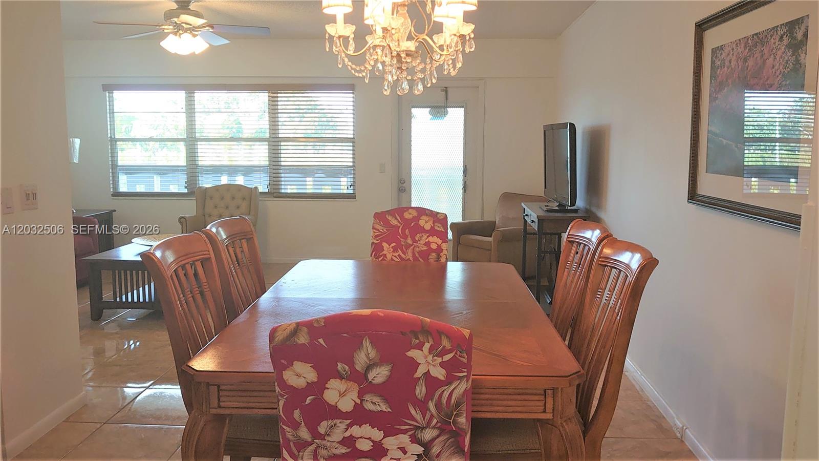 A dining room features a wooden table, floral chairs, a chandelier, and tile flooring — 250 Suffolk F # 250, Boca Raton FL 33434, BOCA RATON, FL