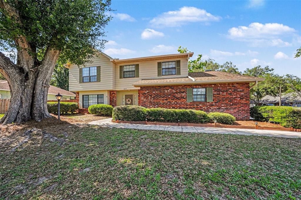 A two-story house features a brick and siding exterior with a large tree in front — 6612 PEACHTREE DRIVE, TAMPA, FL