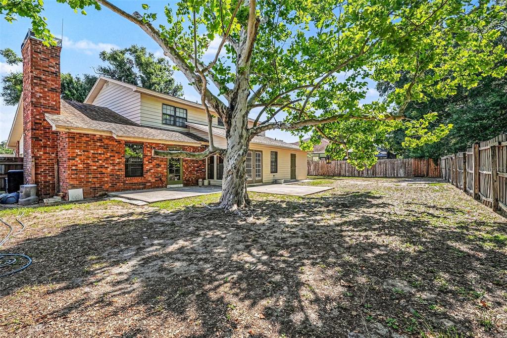 A brick and siding house with a large tree in the backyard and wooden fencing — 6612 PEACHTREE DRIVE, TAMPA, FL