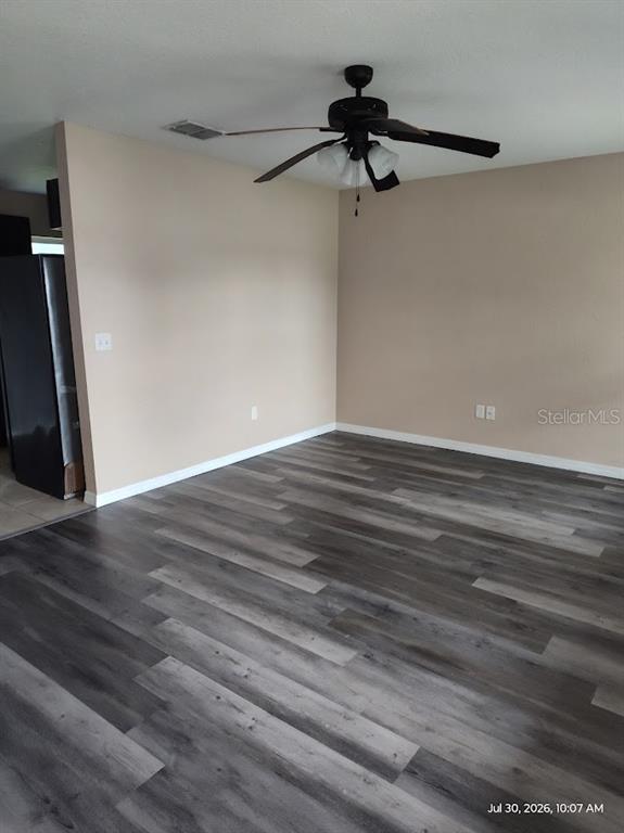 A room with light-colored walls, a dark ceiling fan, and gray wood-look flooring — 17184 SW 44TH CIRCLE, OCALA, FL