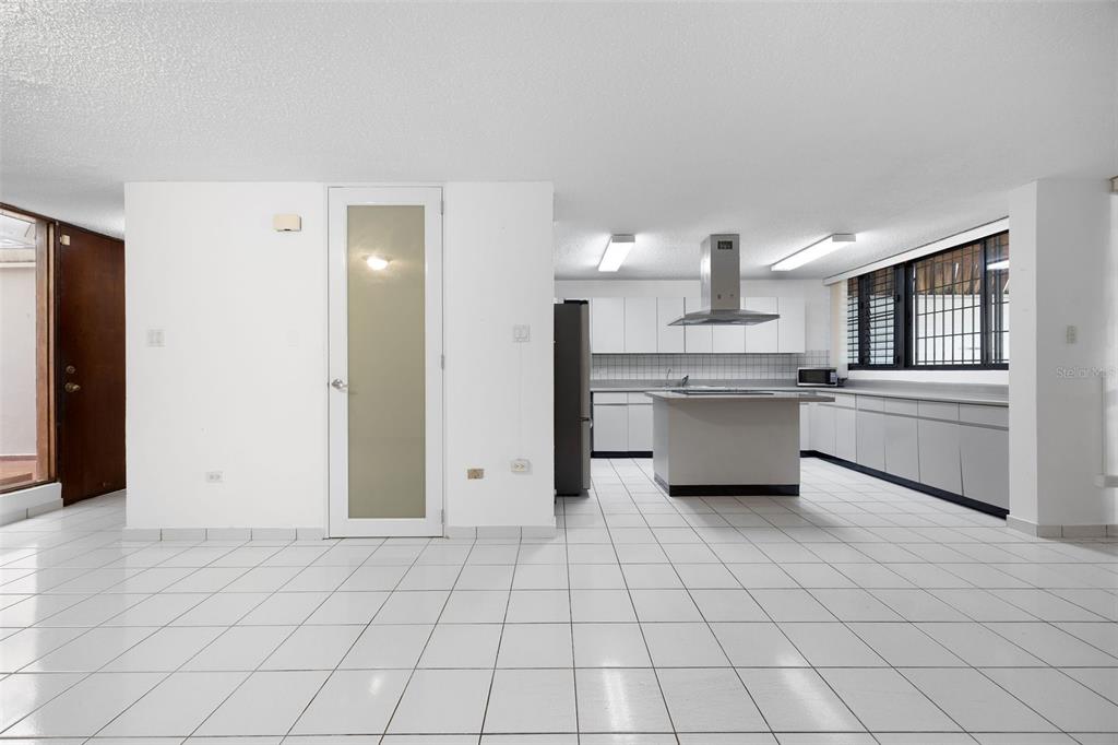 A spacious kitchen and dining area with white cabinets, a center island, and tiled floors — B-14 CALLE SEVILLA BILTMORE, GUAYNABO, PR