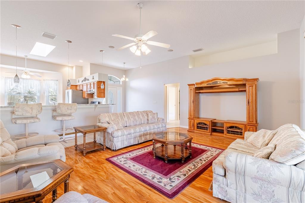 A kitchen with wood cabinets, granite countertops, a breakfast bar, and a bay window area — 5732 FREEPORT DRIVE, TAVARES, FL
