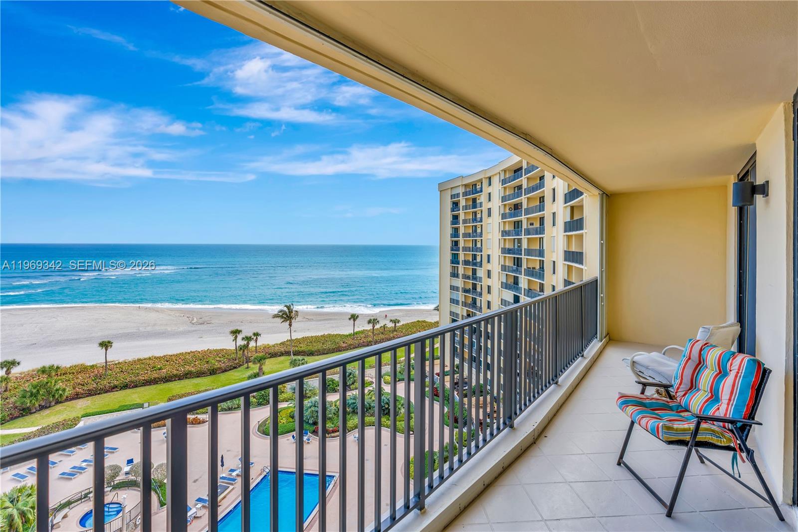 A balcony with a metal railing overlooks a beach, ocean, and a swimming pool below — 300 Ocean Trail Way # 1008, Jupiter FL 33477, JUPITER, FL
