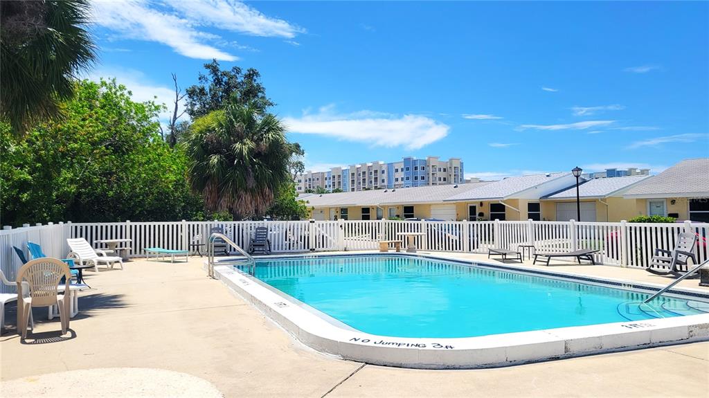 An outdoor swimming pool surrounded by a white fence and patio furniture — 4913 GETNER STREET, NEW PORT RICHEY, FL
