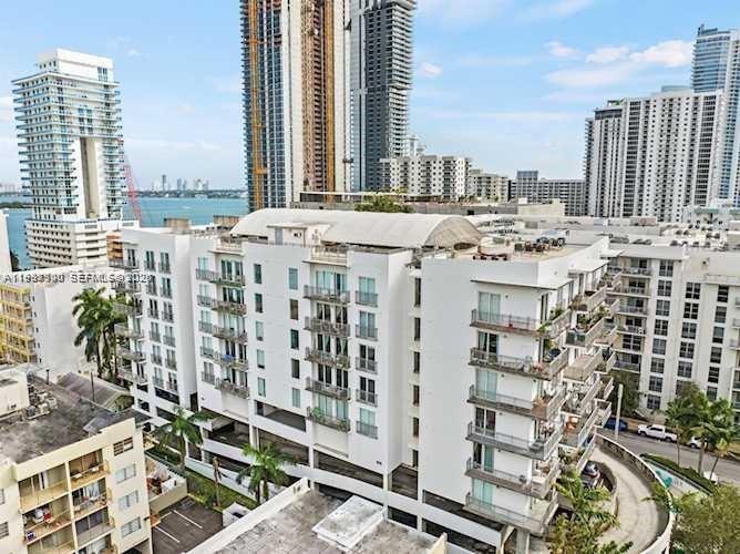 An aerial view of a white multi-story apartment building with balconies in a city — 455 NE 25th St # 407, Miami FL 33137, MIAMI, FL