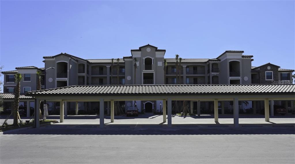 A multi-story apartment building with a covered parking structure in the foreground — 16804 VARDON TERRACE UNIT 206, LAKEWOOD RANCH, FL