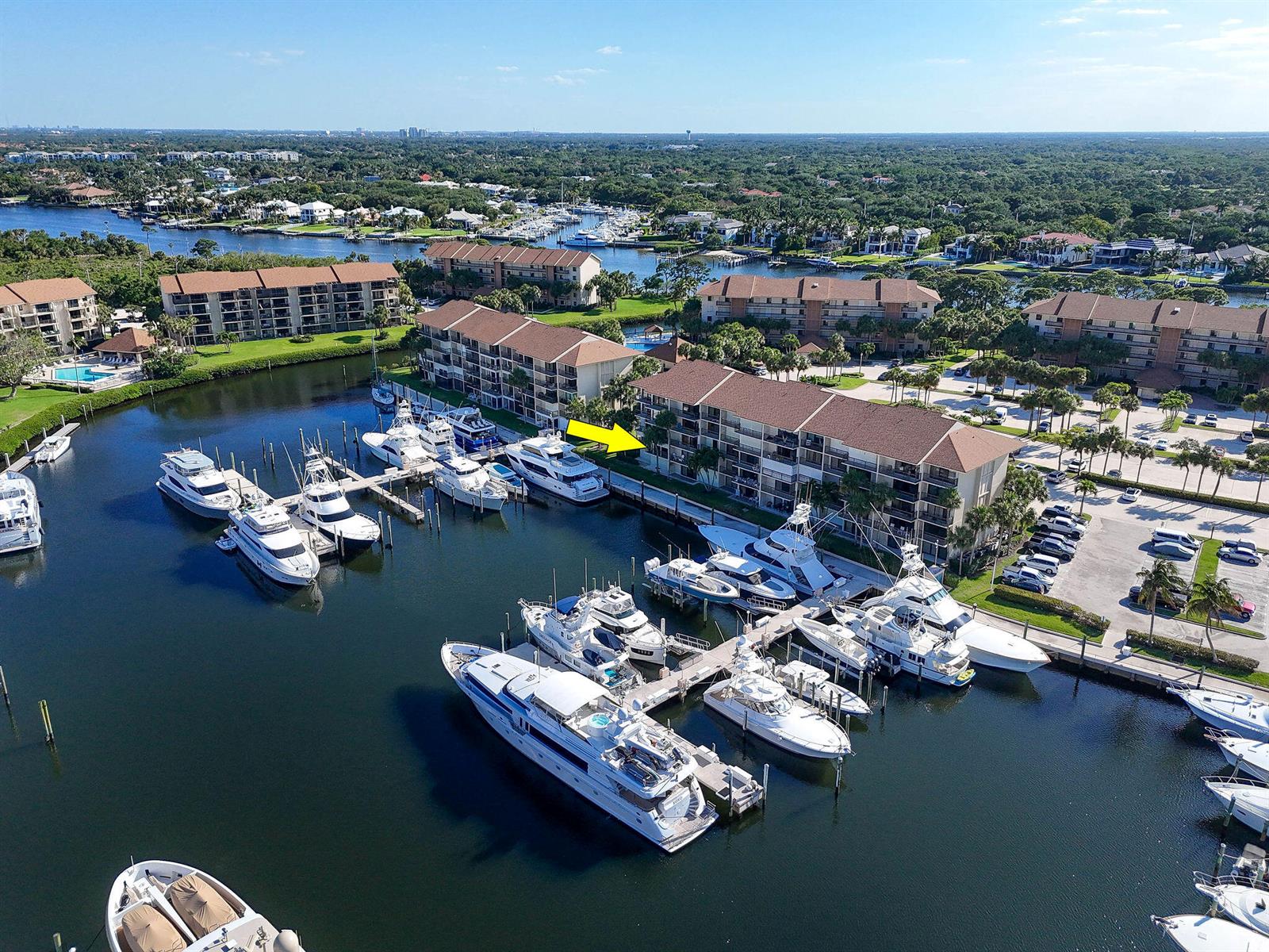An aerial view shows a multi-story residential building with a marina full of docked yachts — 2401 Marina Isle Way # 206, Jupiter FL 33477, JUPITER, FL