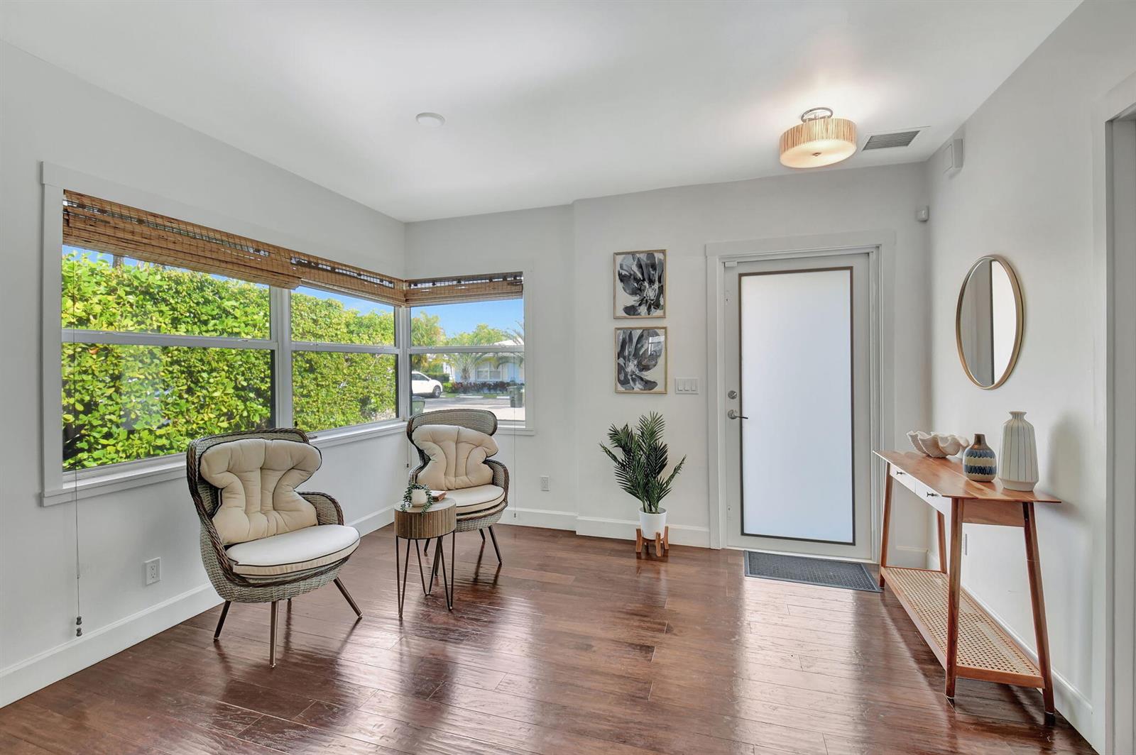 A bright entryway features hardwood floors, two wicker chairs, a console table, and a glass door — 414 NE 7th Avenue, Delray Beach FL 33483, DELRAY BEACH, FL