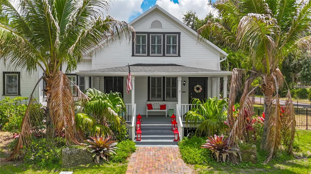 A white two-story house with a front porch, palm trees, and a brick walkway — 3621 1ST AVENUE W, BRADENTON, FL
