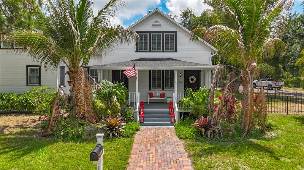 A white two-story house with a brick walkway, front porch, and palm trees — 3621 1ST AVENUE W, BRADENTON, FL